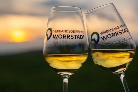 Zwei Weingläser der Verbandsgemeinde Wörrstadt vor einem Sonnenuntergang